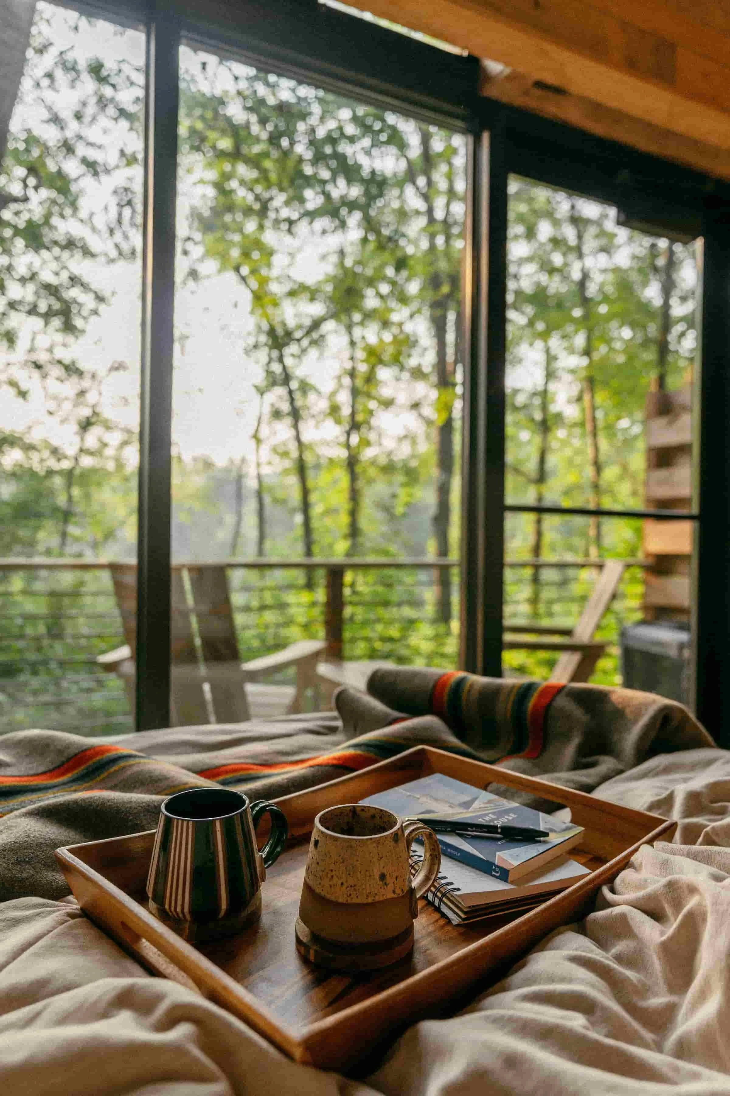 Modern cabin interior at Cuyuna Cove with forest views from bed and deck near Cuyuna Country State Recreation Area in Crosby Minnesota