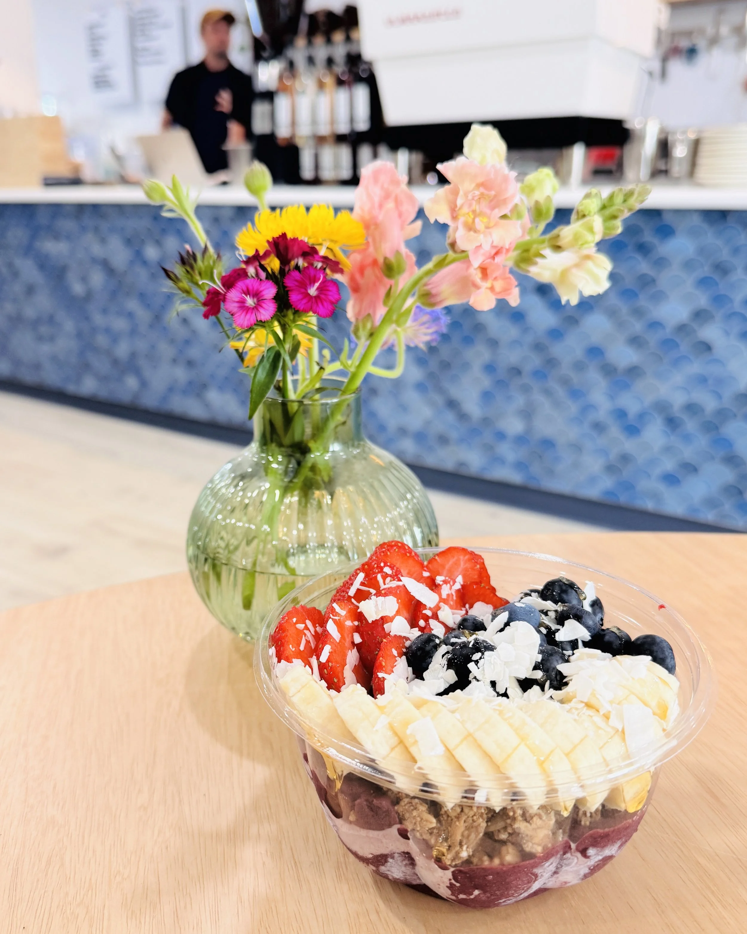 Acai bowl with flowers on a wood table at Cove & Co. in Homer, Alaska on the Homer Spit.