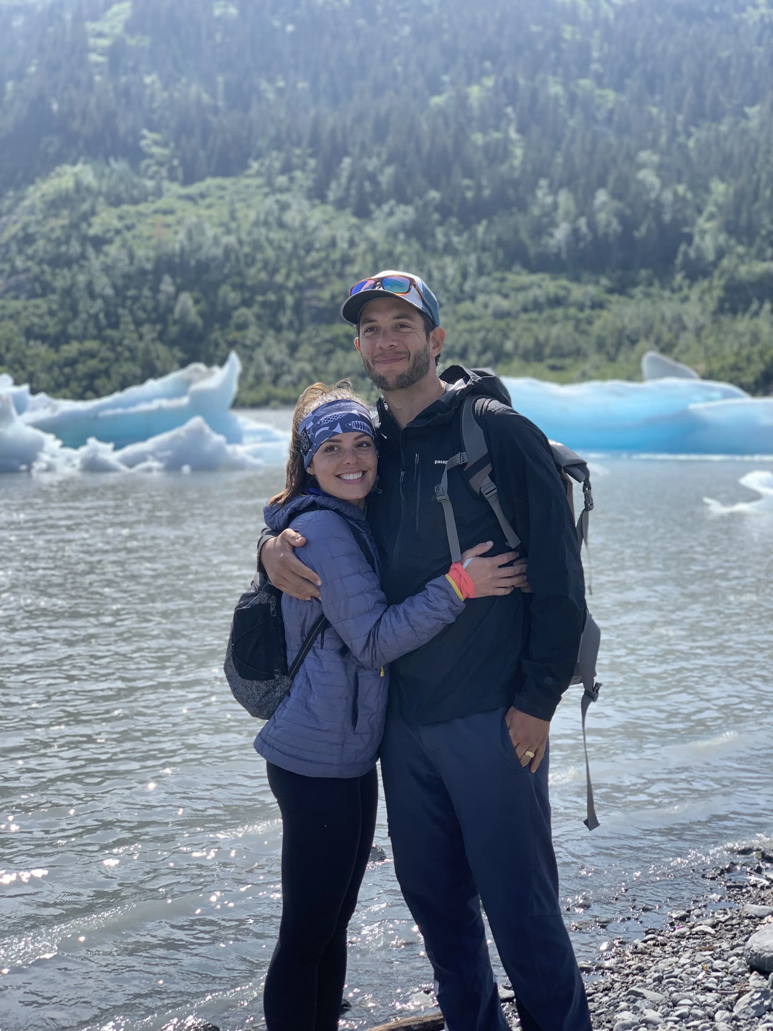 Couple standing in front of Grewingk Glacier Lake outside of Homer, Alaska.