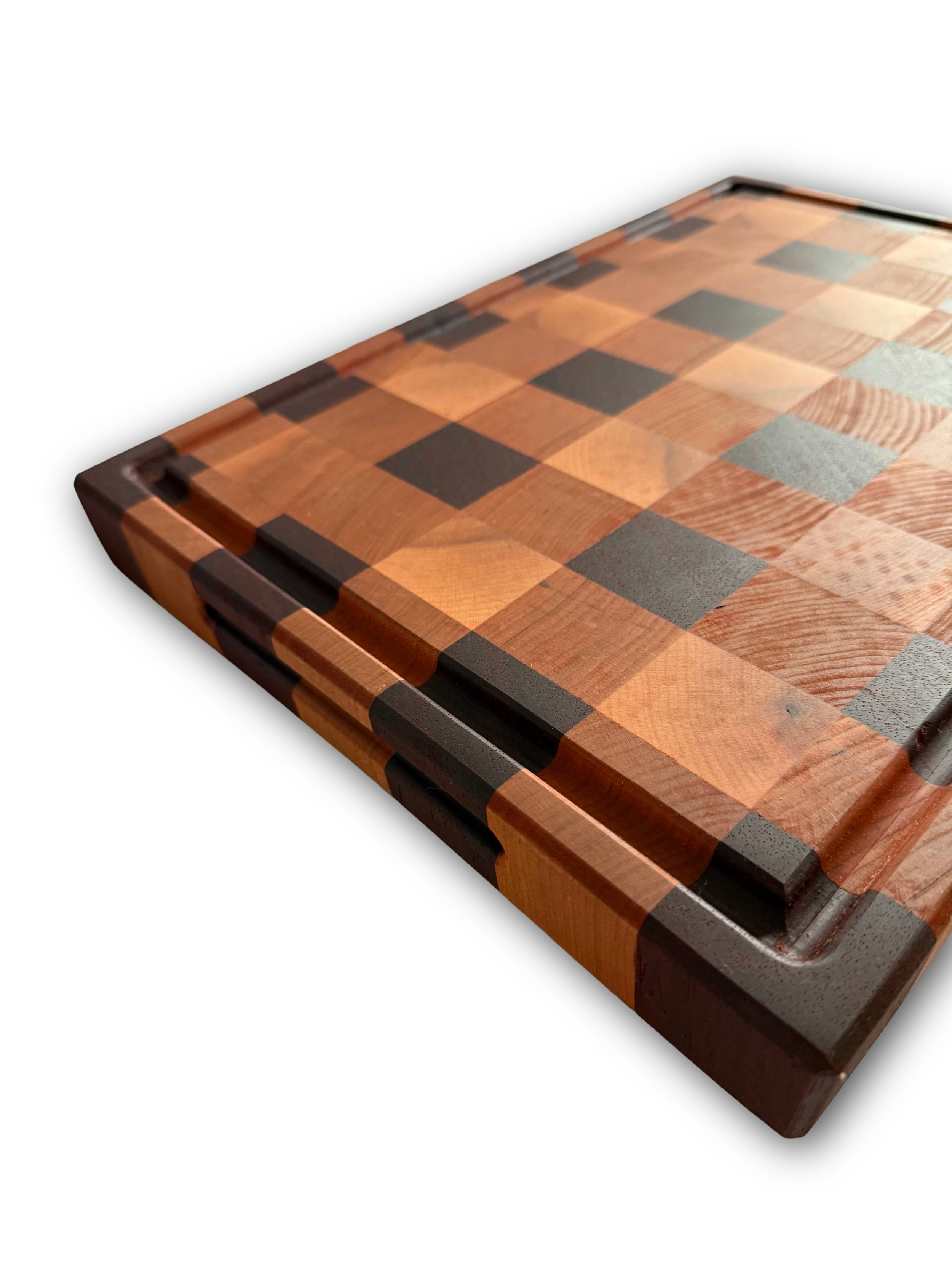 Close-up of a wooden cutting board with a checkered pattern of various wood tones and dark accents.