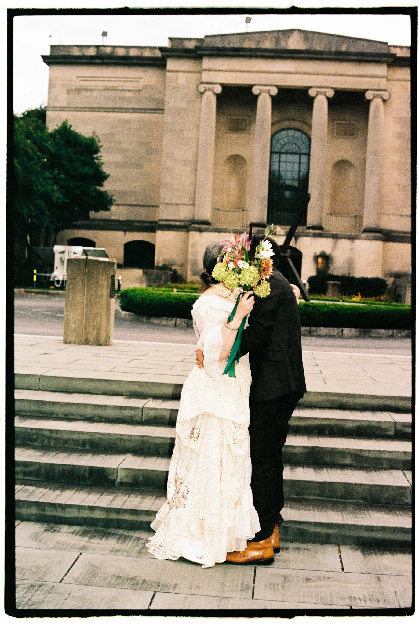 bride and groom kissing with stairs behind them