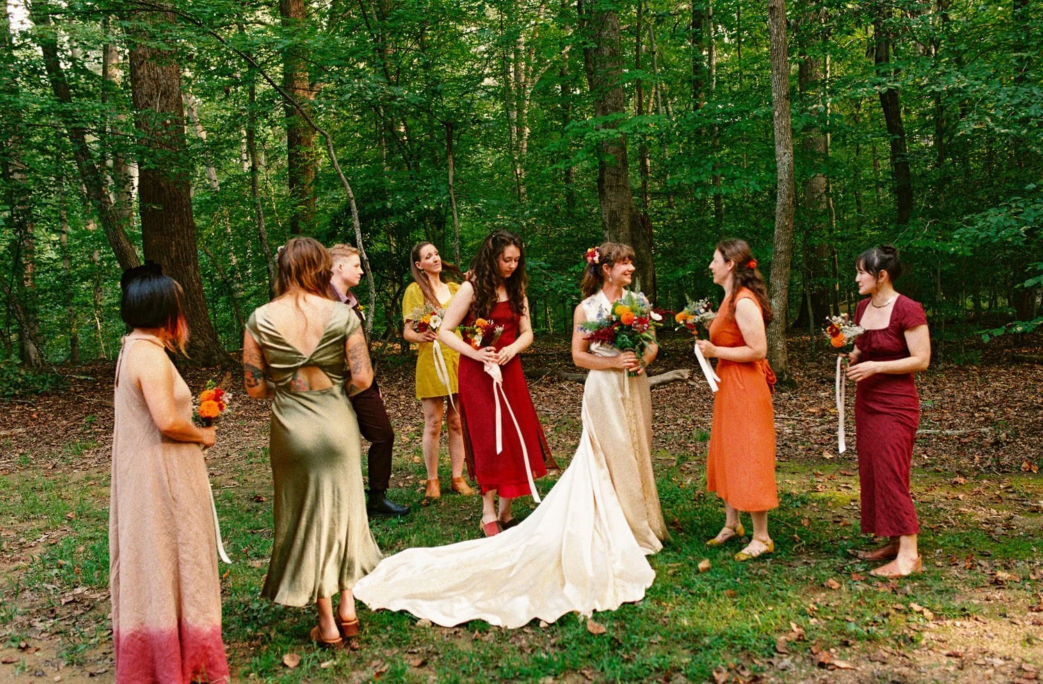 candid moment of bride and bridesmaids outdoors in woods