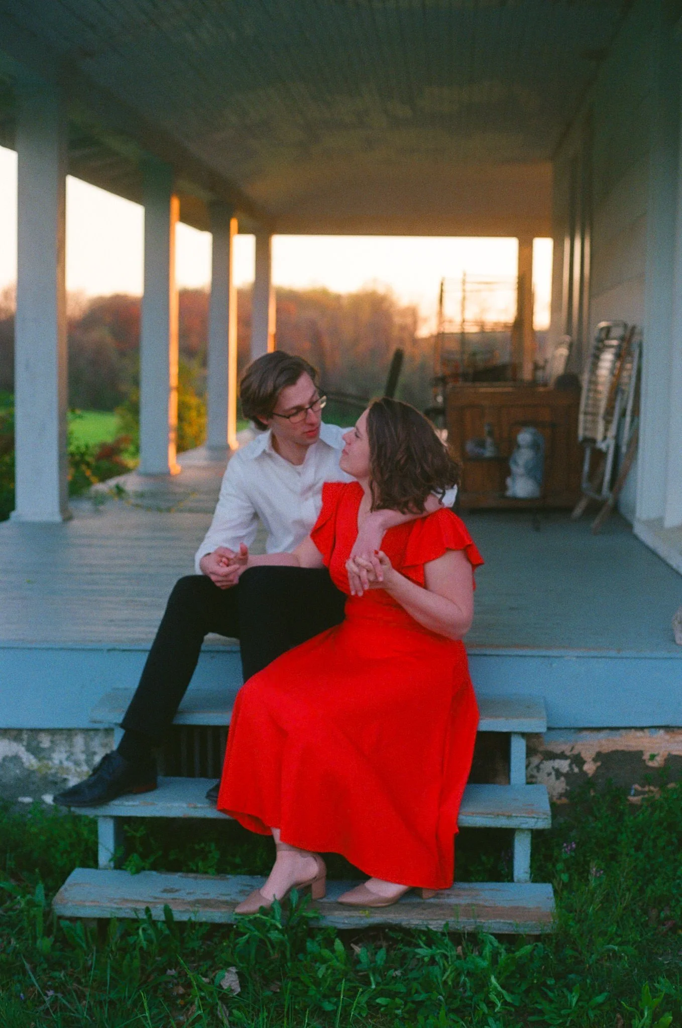 backyard engagement session with red dress on steps
