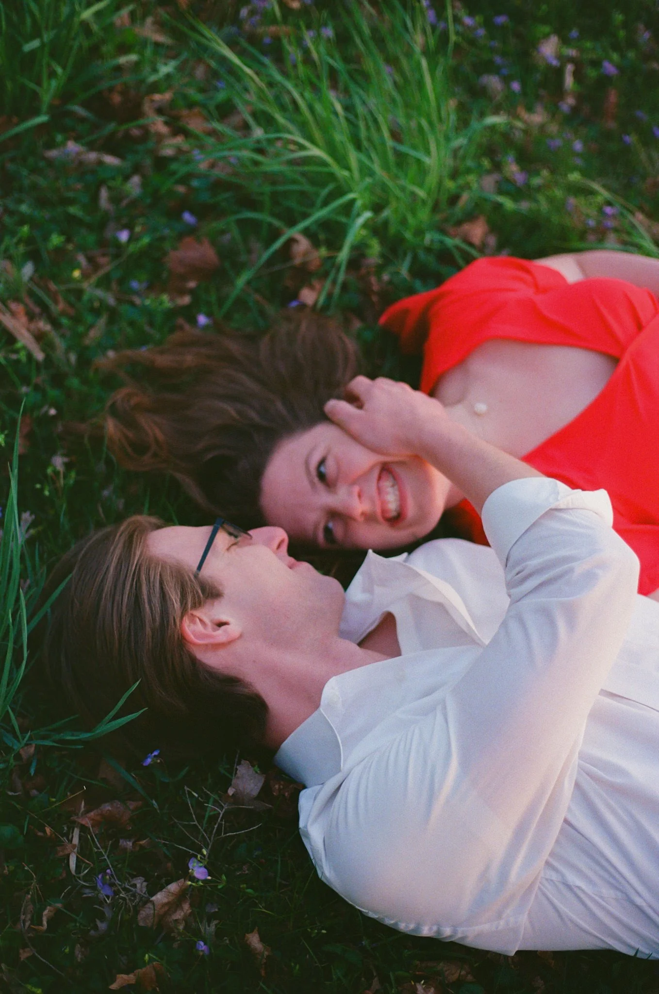couple laying in grass kissing