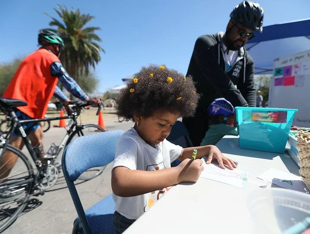 Image of a child coloring at the Southern Arizona Microschool Collective's table at the April 2025 Cyclovia event