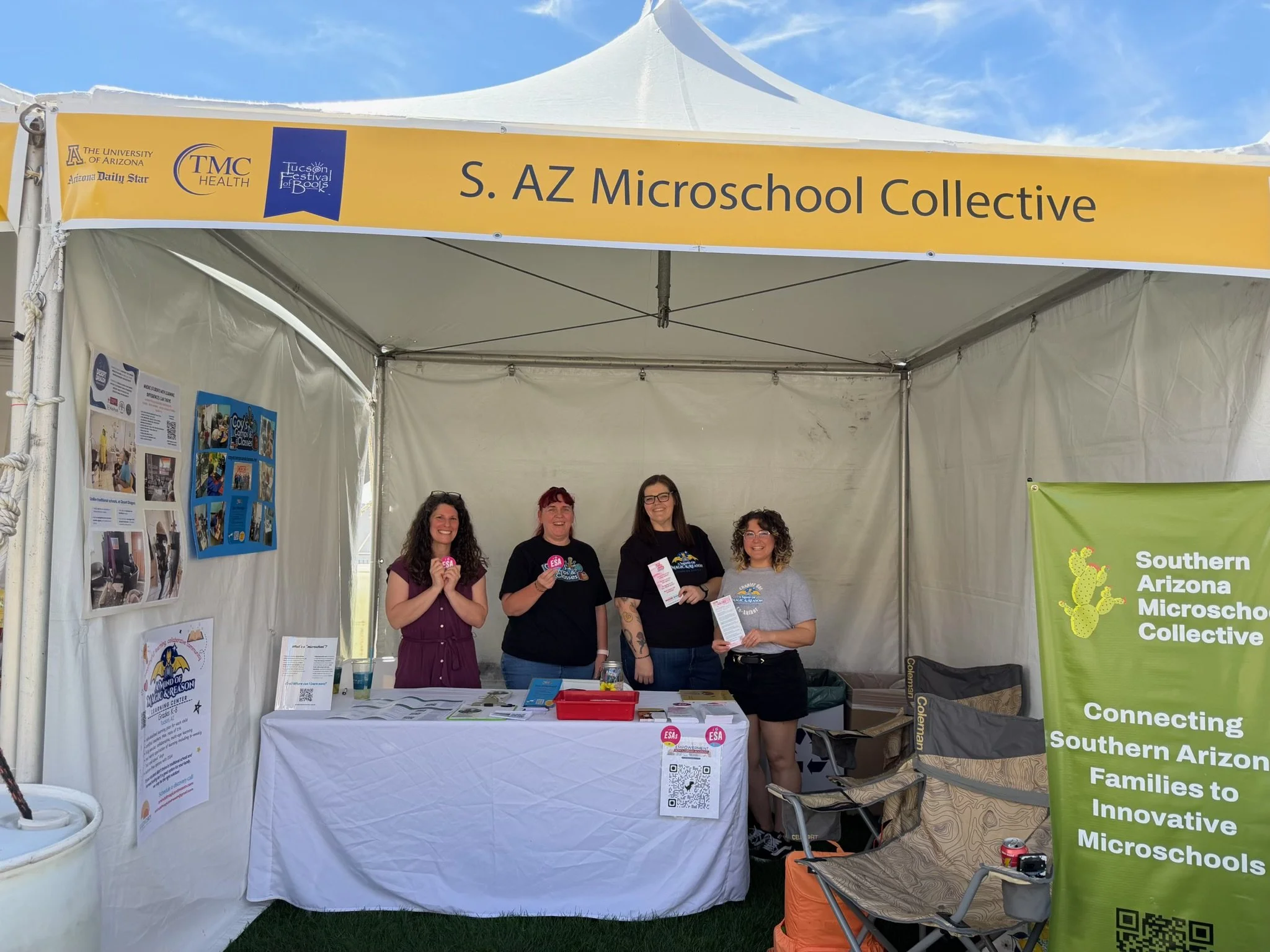 Microschool founders inside the Southern Arizona Microschool Collective booth at the Tucson Festival of Books 2026. Each founder is holding up information and standing behind a table.