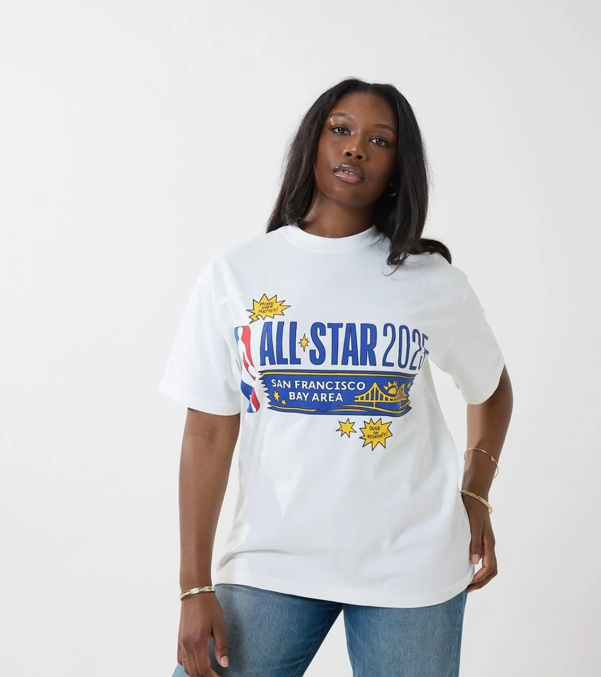 Woman with dark hair wearing a white NBA All-Star 2022 T-shirt with graphics and text related to San Francisco Bay Area and basketball.