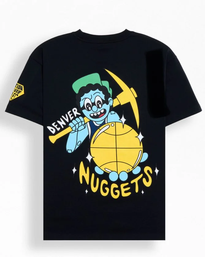 Black T-shirt featuring a cartoon character with glasses and dark curly hair holding a large yellow nugget and a pickaxe, with the words "Denver Nuggets" and sparkling effects.