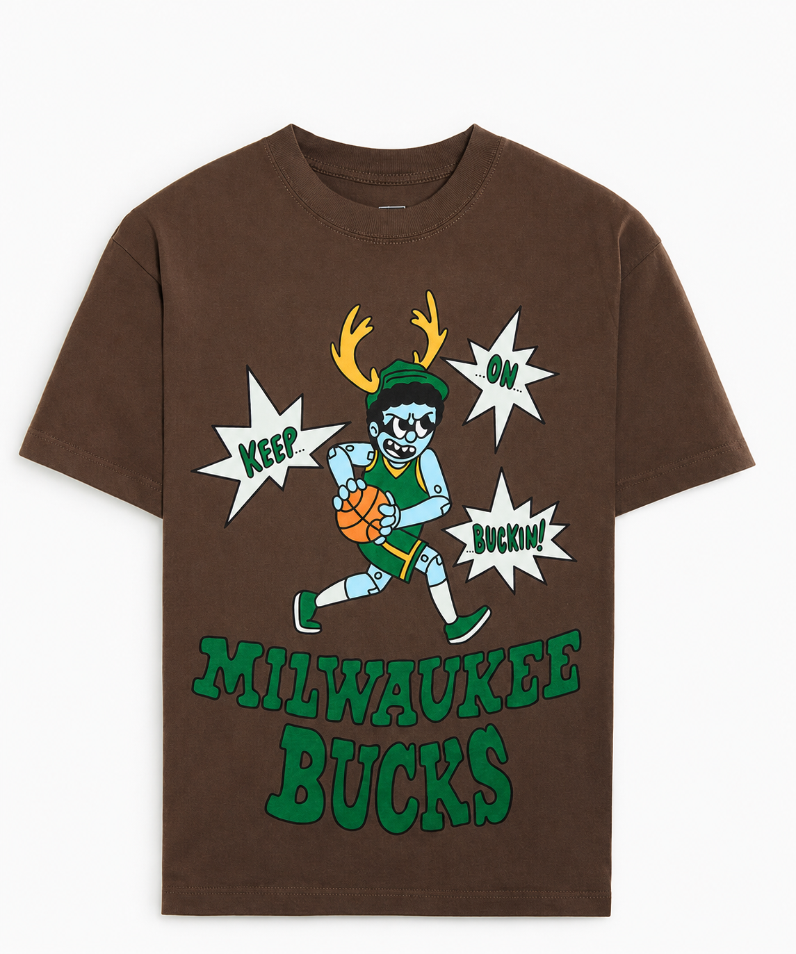 Brown T-shirt with cartoon of a basketball player with antlers, wearing green and yellow, holding a basketball, surrounded by comic-style speech bubbles saying "Keep On Buckin'!" and text "Milwaukee Bucks" at the bottom.