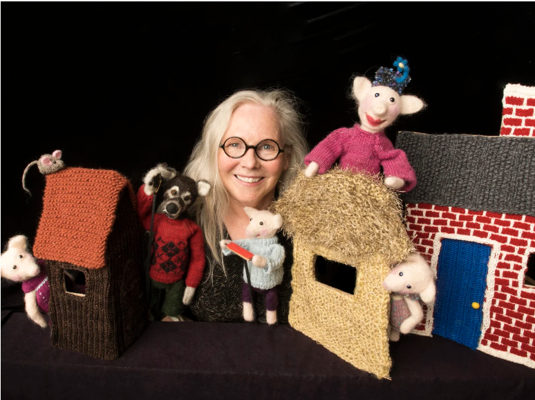 One person with glasses and a live long and prosper t-shirts holds another person in a red sweater on their shoulders