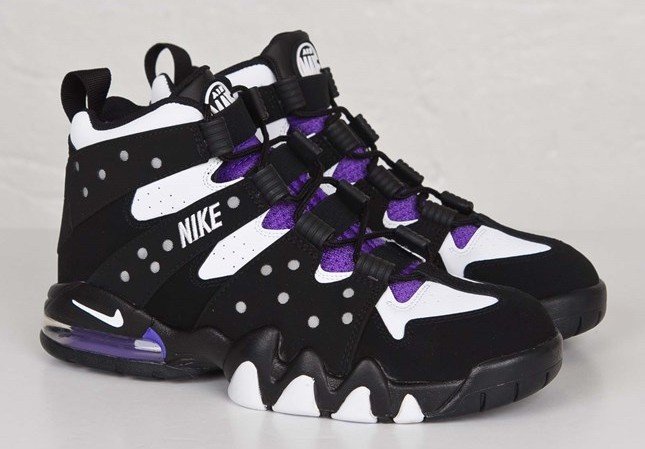Black, white, purple, and black Nike sneakers with a high-top design and decorative spots.