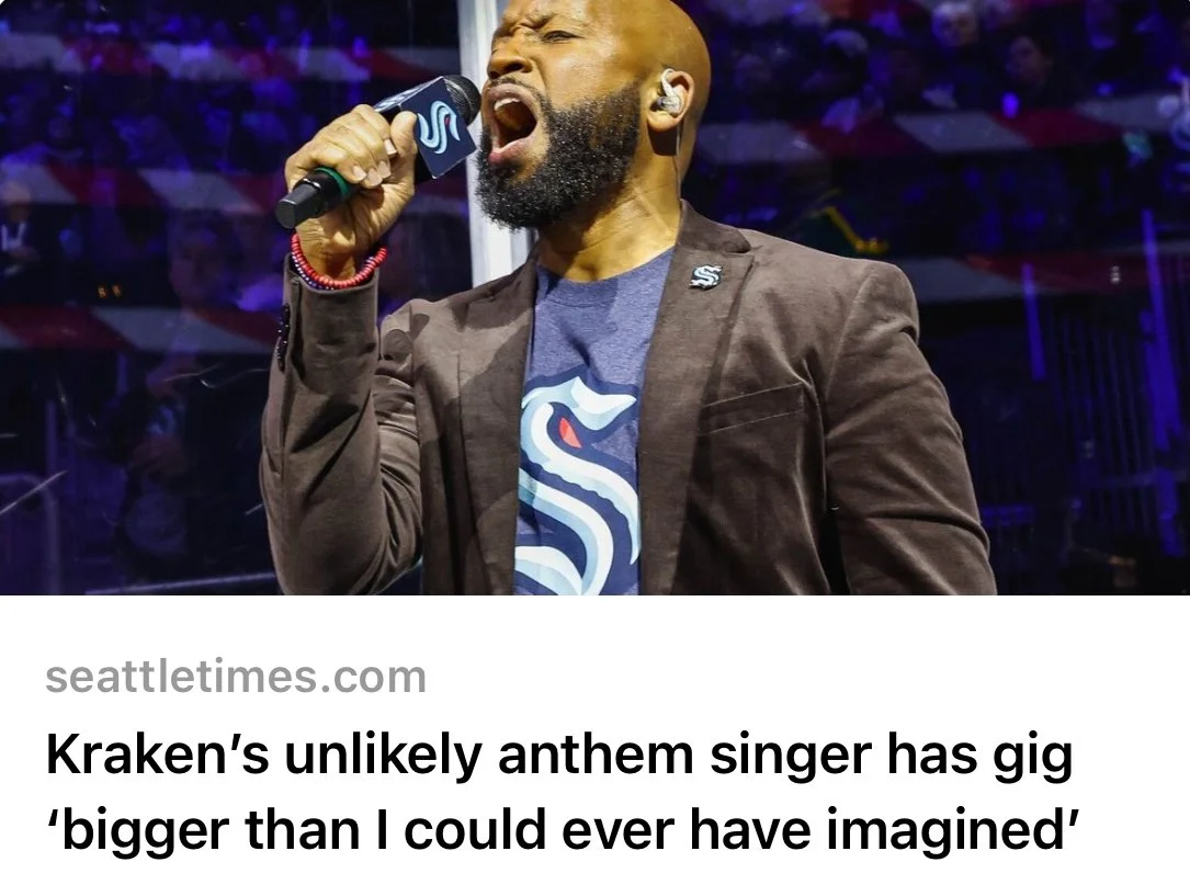 Man passionately singing into a microphone with Seattle Kraken logo.