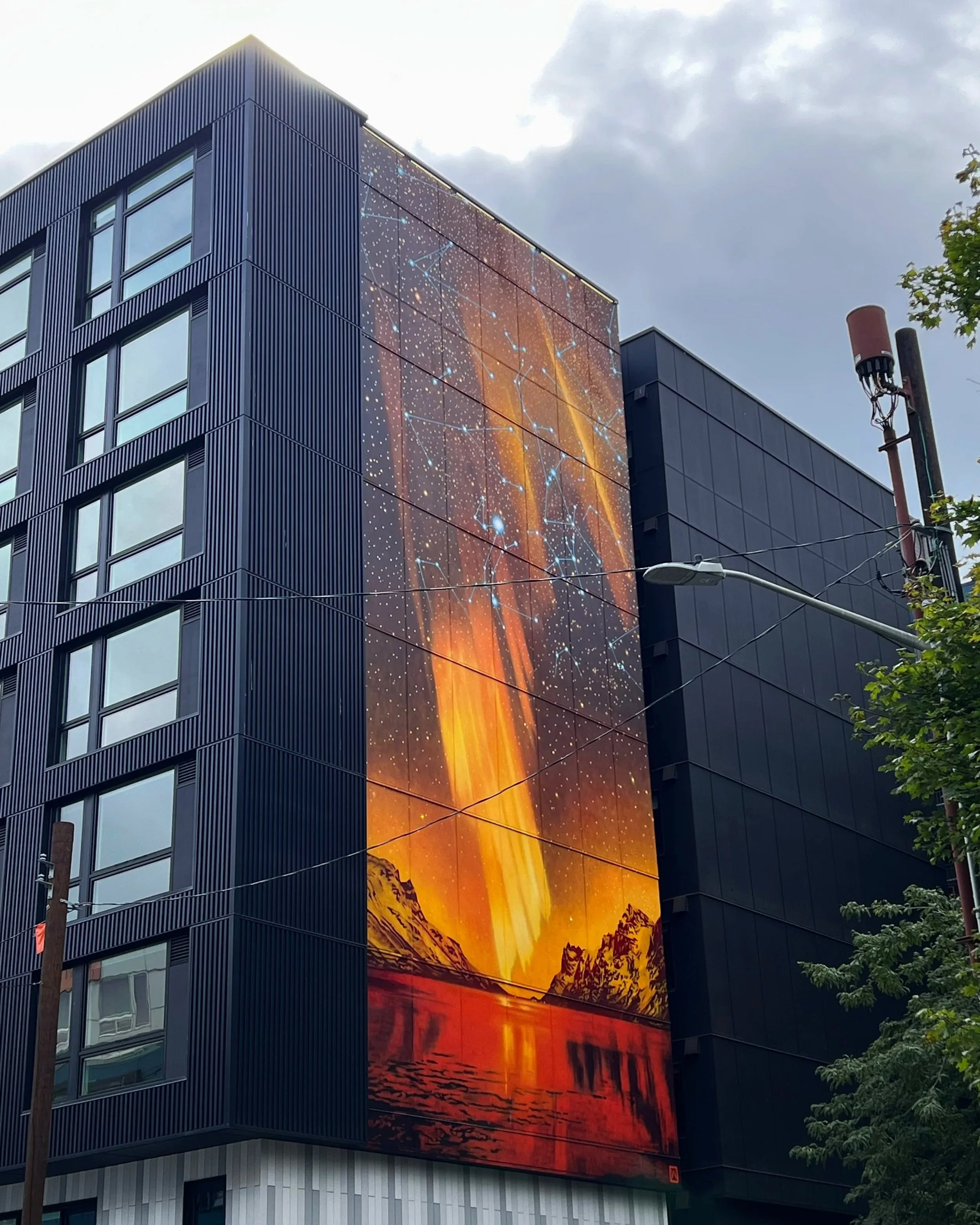 6 story amber toned aurora mural for Stellar Apartments - Seattle WA