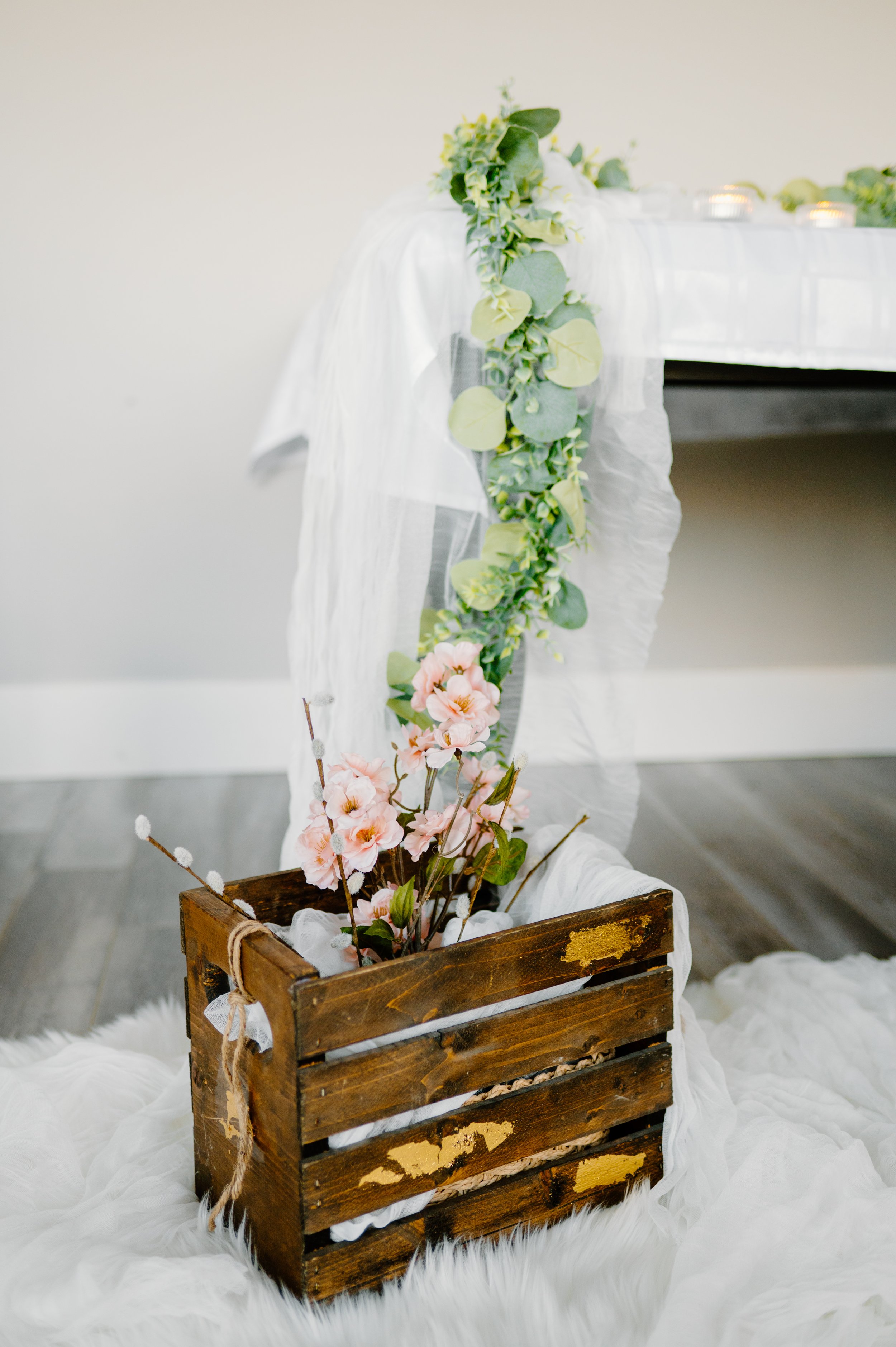 Small wood crate with faux flowers and gauze
9.5 "H, 12" L, 7.5"W. 1 day rental is $30.
