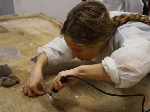 Painting conservator working on canvas treatment at MPW Art Restoration Studio in Toronto