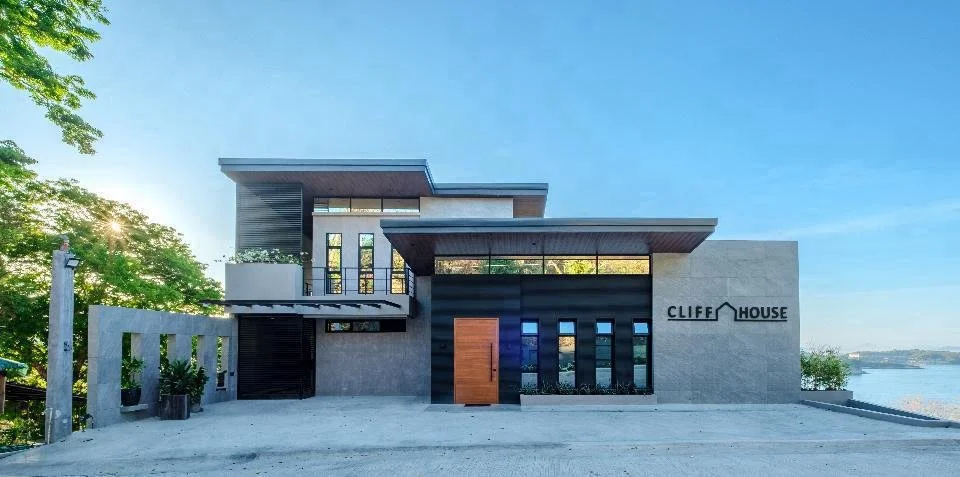 Modern multi-story building with an outdoor swimming pool and lounge chairs.