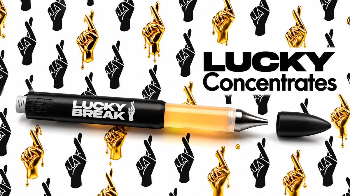 A pen with the words "Lucky Break" and a logo of a hand holding a pen, placed on a background with a pattern of black and gold hand gestures making the peace sign, along with the text "Lucky Concentrates."