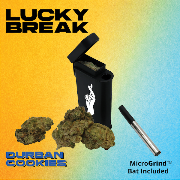 A black vape pen with a white illustration of a hand doing the 'peace' sign. Surrounding the vape are cannabis buds. The background is gradient with yellow on the left and blue on the right. Text reads 'Lucky Break,' 'Durban Cookies,' and 'MicroGrind Bat Included.'