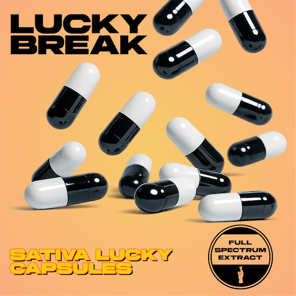 Black and white capsules labeled 'Sativa Lucky Capsules' with words 'Lucky Break' and 'Full Spectrum Extract' on a peach background.