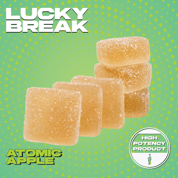 Package of gummy candies labeled 'Lucky Break Atomic Apple' with five candies visible. The background is green with yellow dots and a white badge indicating 'High Potency Product'.