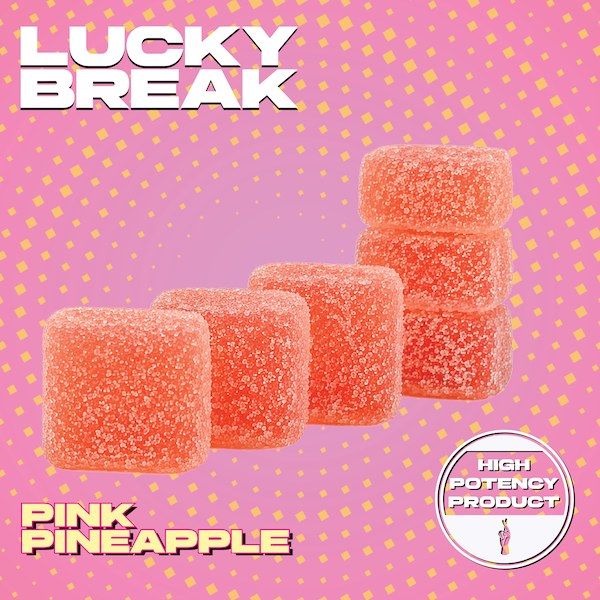 Pink pineapple-flavored gummy candies arranged in a row on a pink background with yellow dots, labeled as "Lucky Break Pink Pineapple" and "High Potency Product."