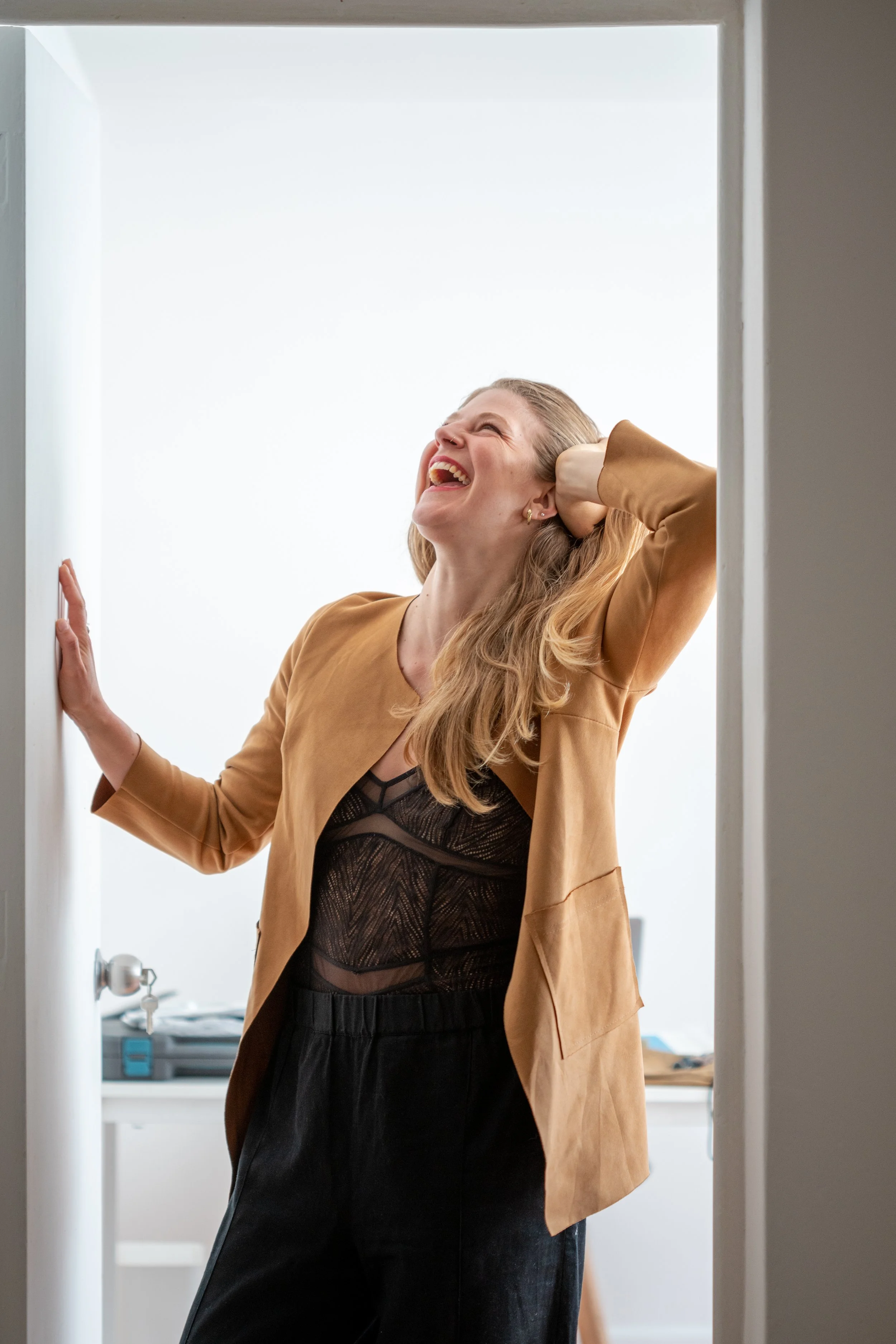 Flora Petri alive free experience, laughing and leaning in door frame.