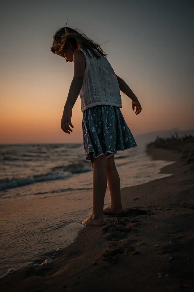 Mädchen am Strand bei Sonnenuntergang