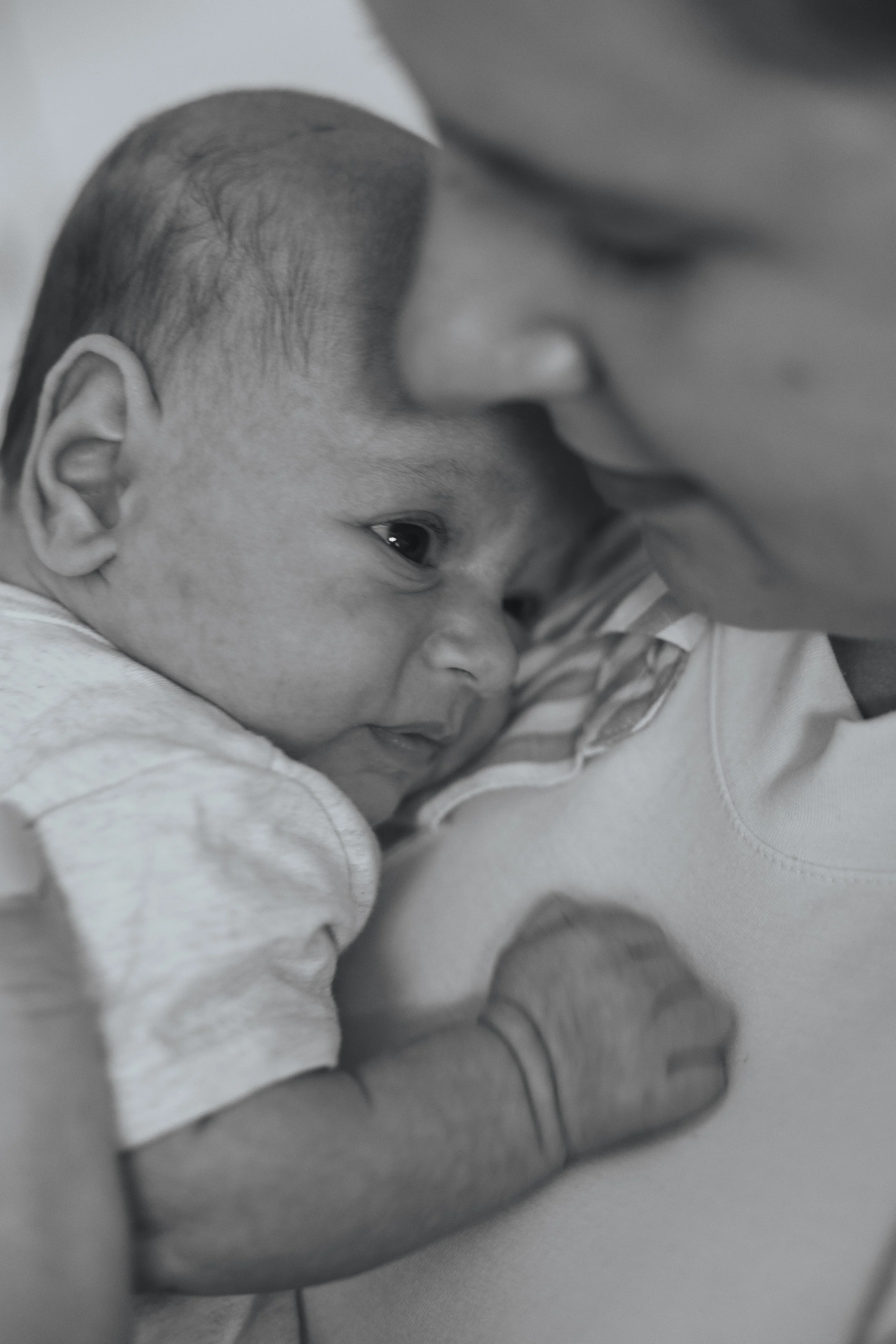 A young child hugging a woman, resting their forehead against her face, showing a tender moment.