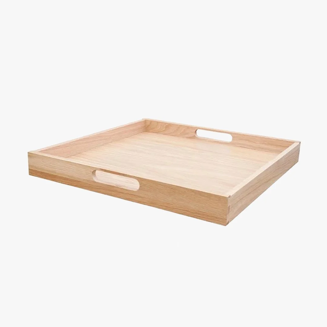 Empty wooden serving tray with cutout handles on a white background.
