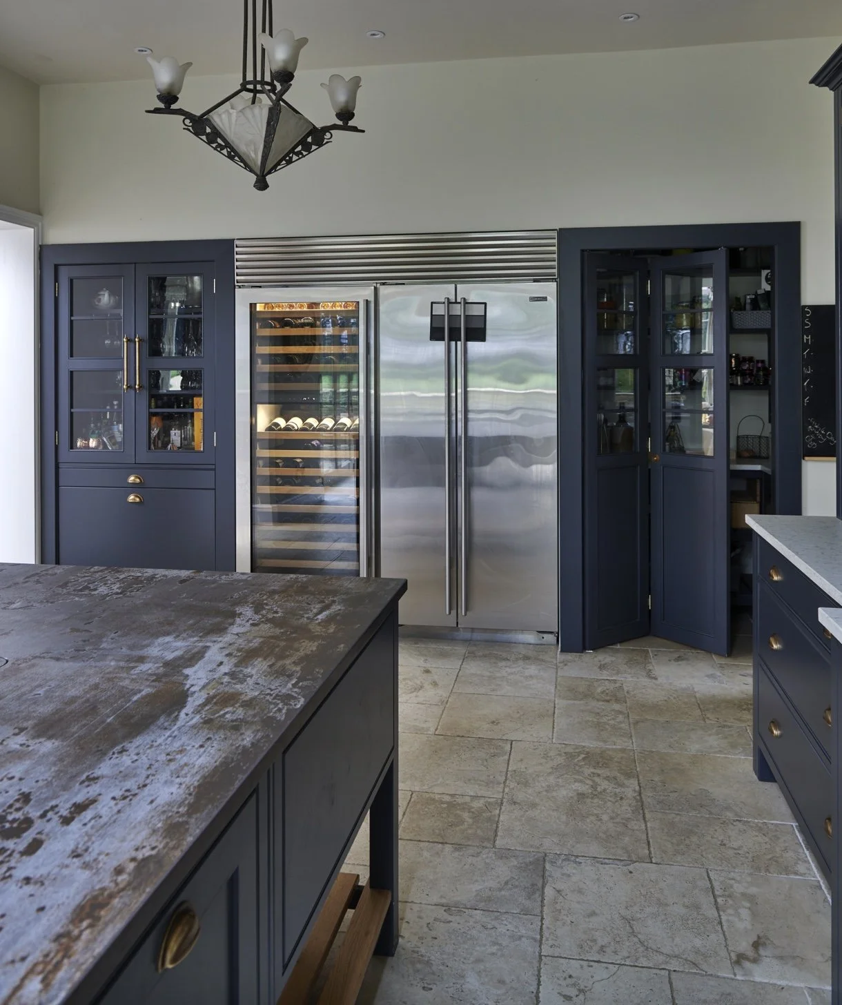 Kitchen with navy blue cabinets and a stainless steel double-door refrigerator, a wine fridge, and a black chalkboard.