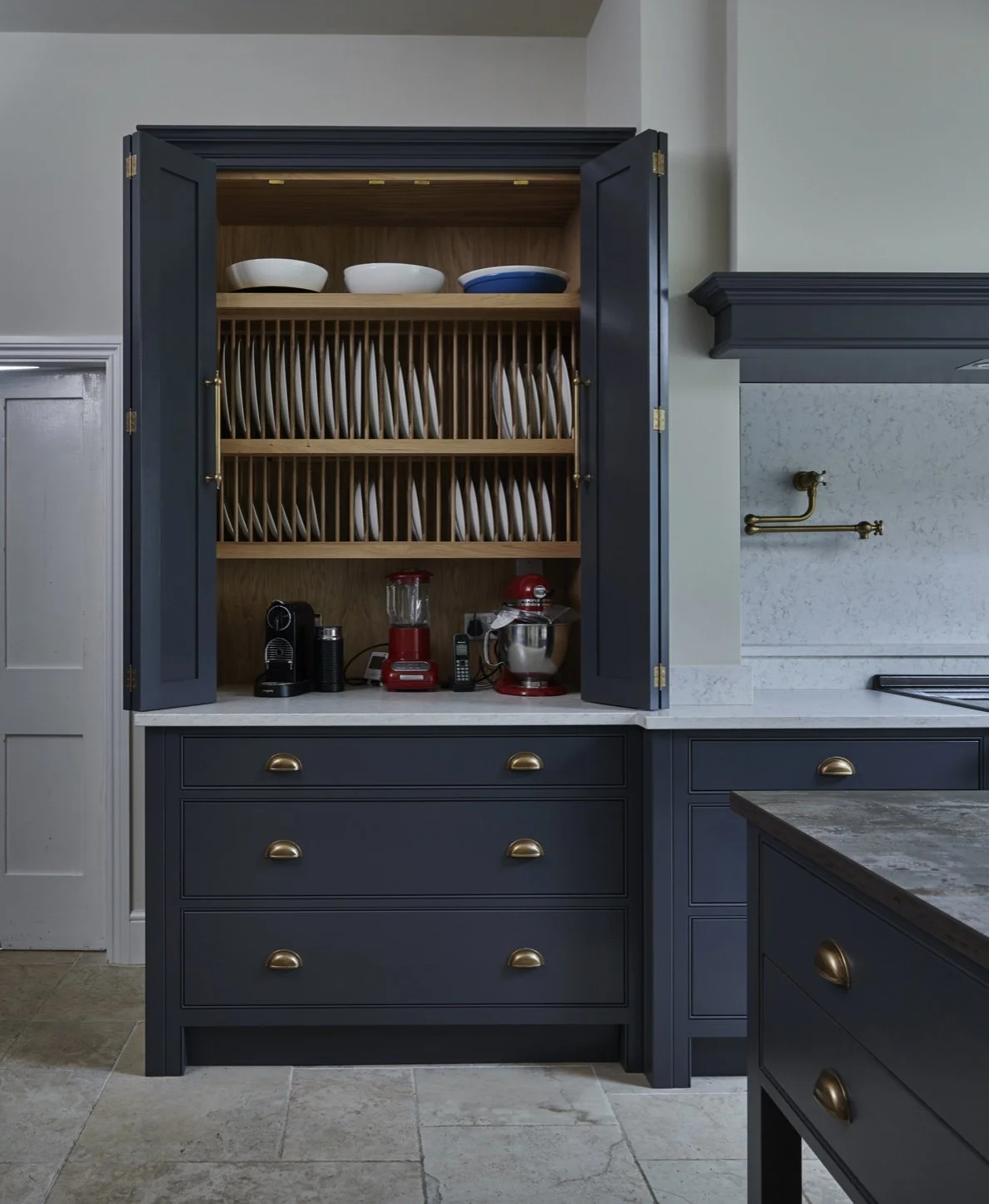 Kitchen cabinet with open doors, displaying dishes, plates, and kitchen appliances.