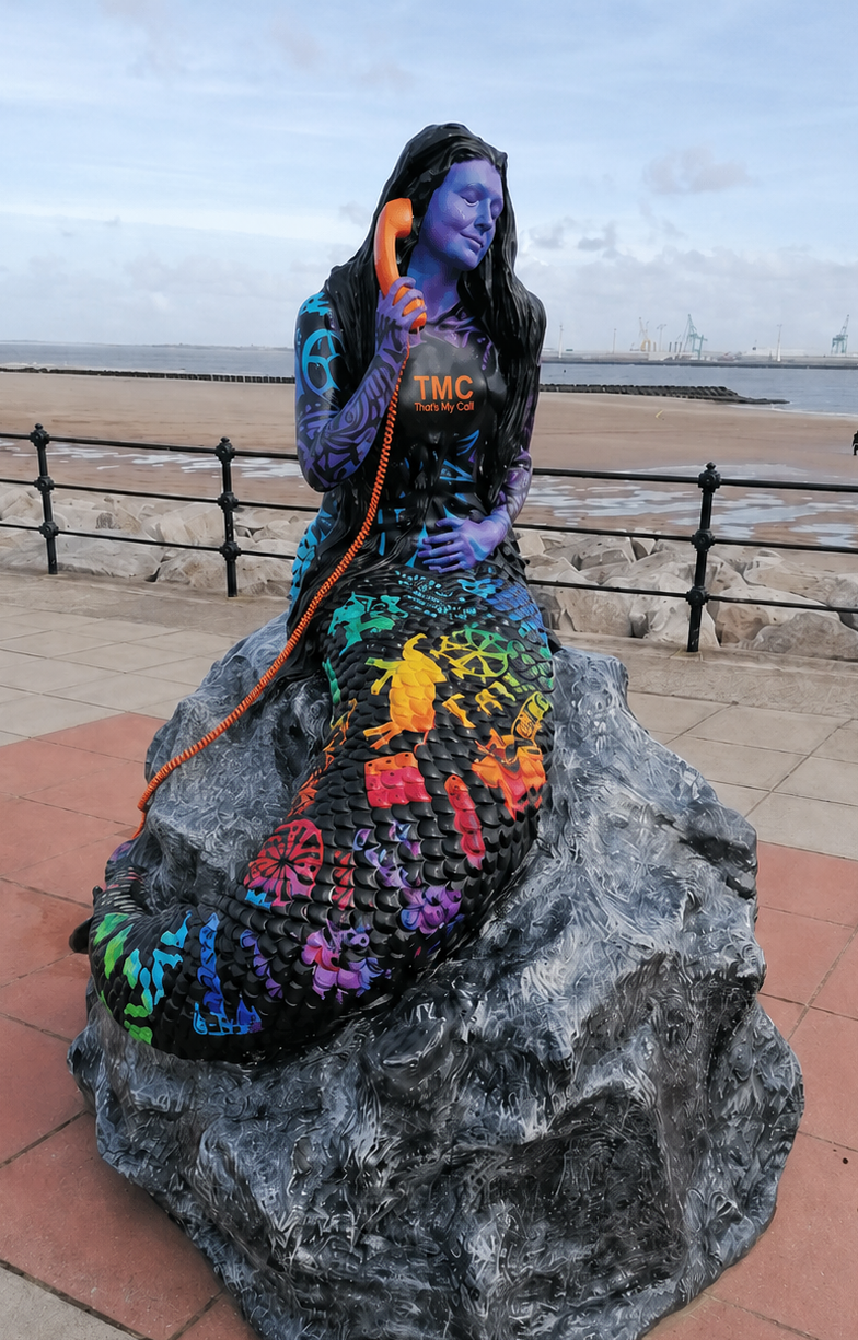 New Brighton Mermaid created by Barry Canning-Eaton using a mould of Cheryl Canning-Eaton’s face, edited with a That’s My Call logo and orange telephone.