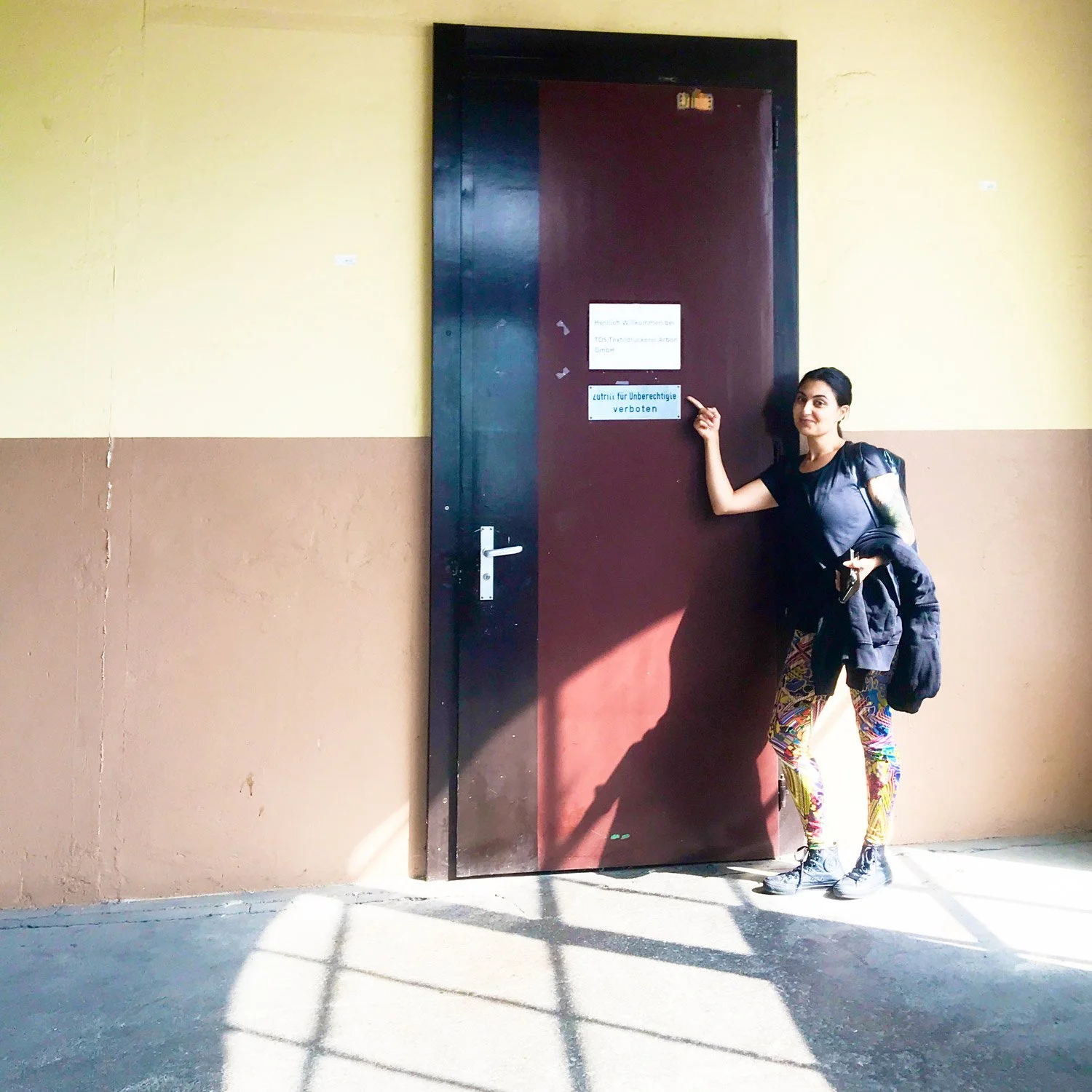 Sanaz in front of the entrance of TDS Druckerei