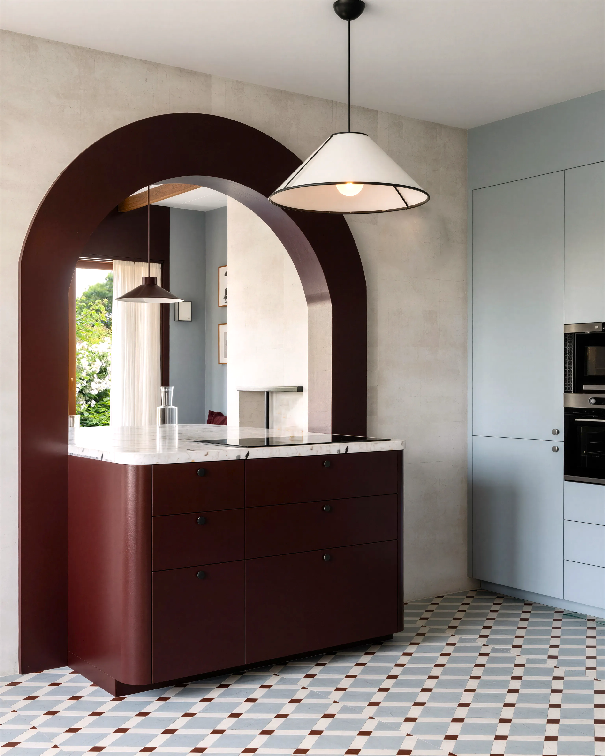Cuisine moderne avec un îlot en marbre blanc, placard en bois foncé, et une lampe suspendue en forme d'abat-jour blanc.