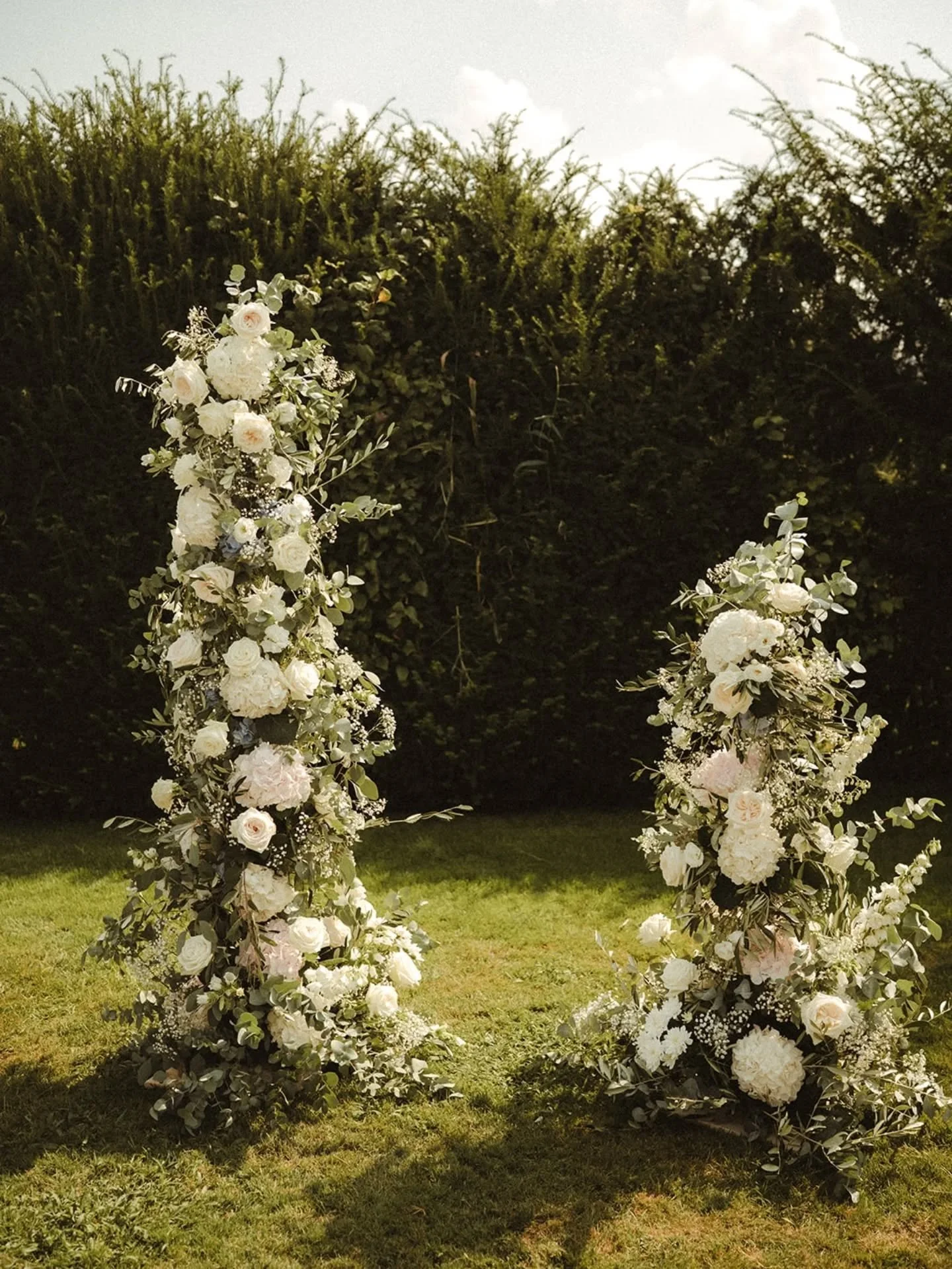 Freie Trauung

Wir lieben Blumens&auml;ulen als Hintergrund f&uuml;r eure freie Trauung. Sie f&uuml;gen sich in die Umgebung ein und k&ouml;nnen nach der Trauung sehr gut als Dekoelement beim Essen oder Rahmen f&uuml;r eure Fotobox wiederverwendet we