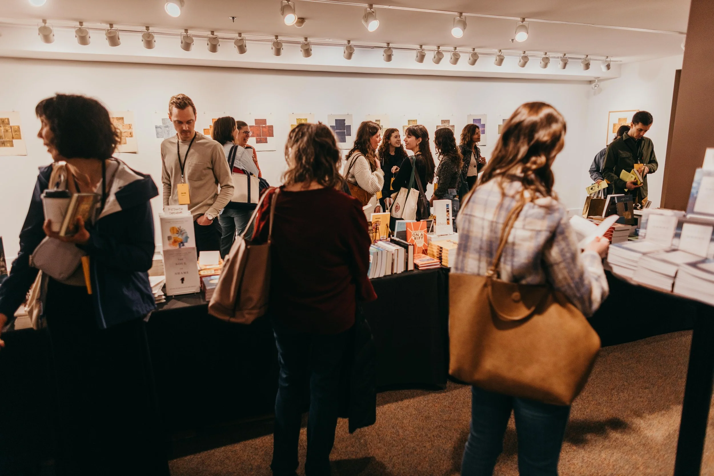 People browsing books at a bookstore or book fair, engaging in conversations and reading.