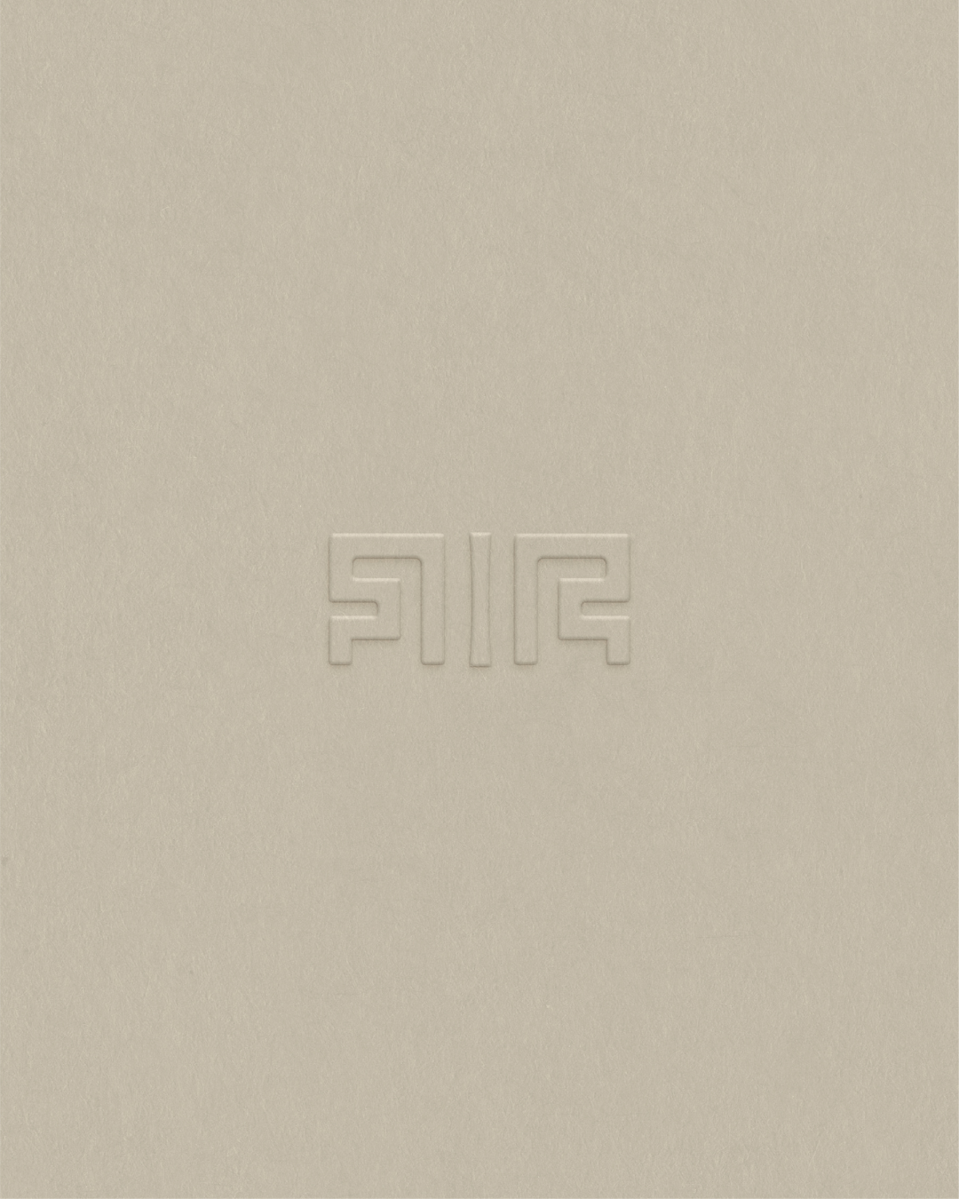 Embossed Richē geometric brand symbol inspired by Kuba textile patterns, printed on textured luxury paper stock in a minimalist wellness branding presentation.