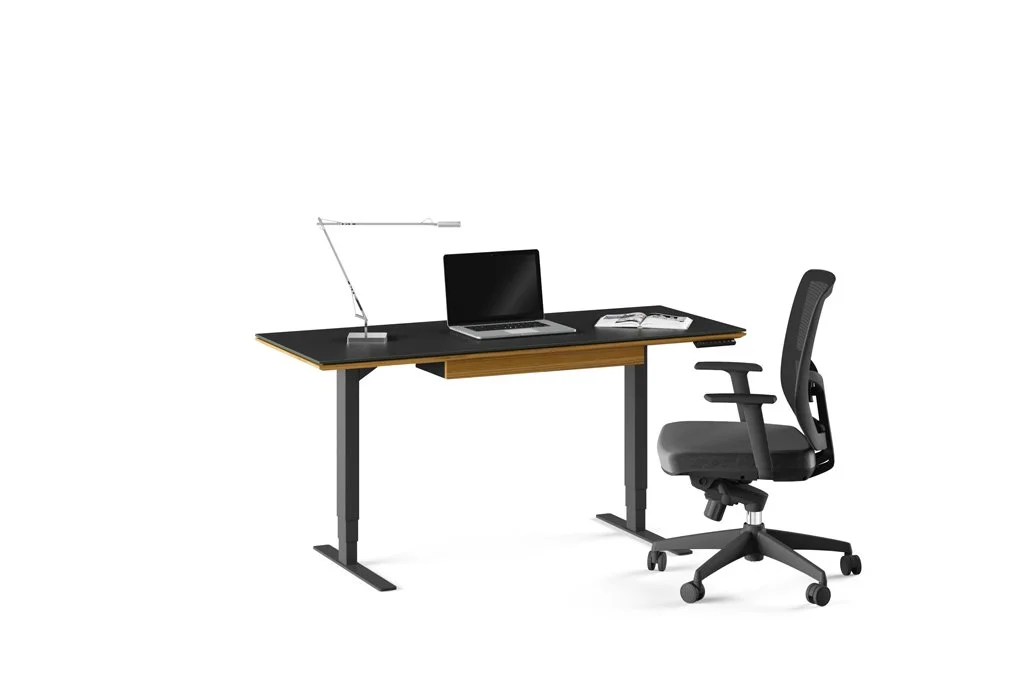 Side view of Sequel Lift Standing Desk at seated height with laptop and task chair