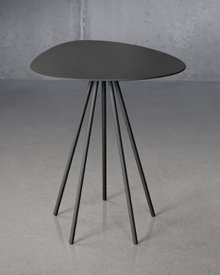 Trica Cloud-5 Accent Table with black organic-shaped top and slim tapered legs against concrete wall