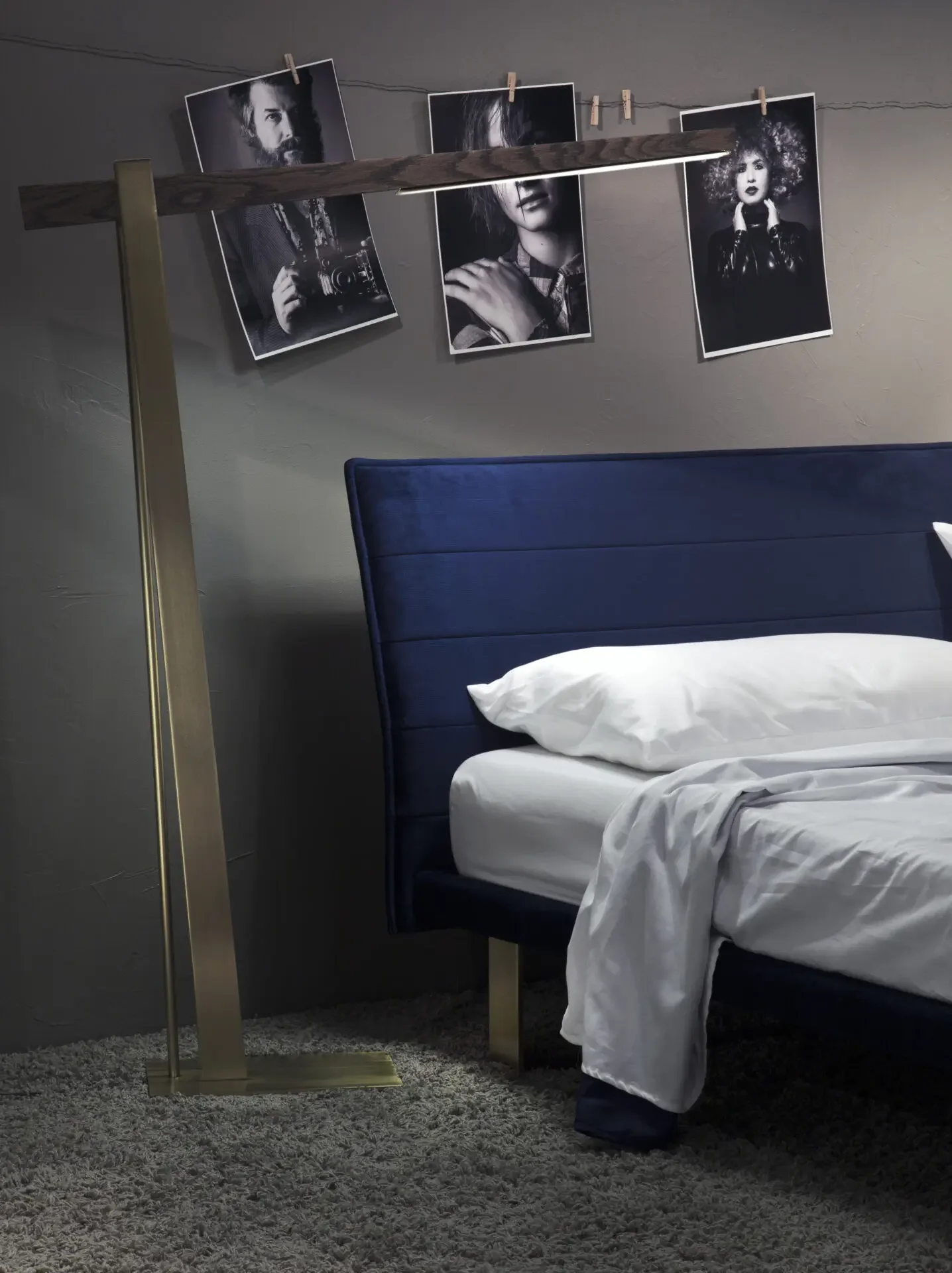 Brass and wood Trica Beam Lamp beside bed in contemporary bedroom setting