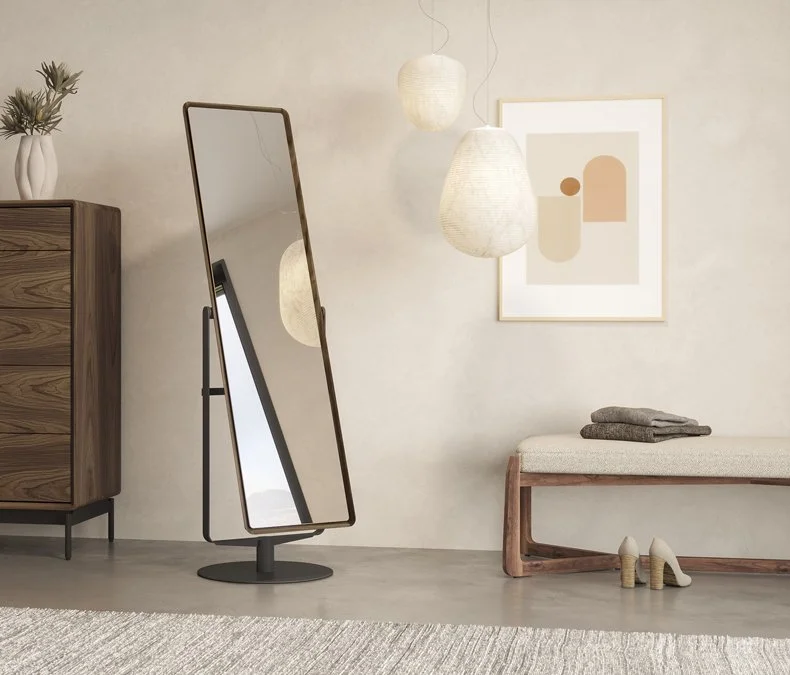Contemporary standing mirror with minimalist frame next to tall dresser and pendant lights in upscale interior