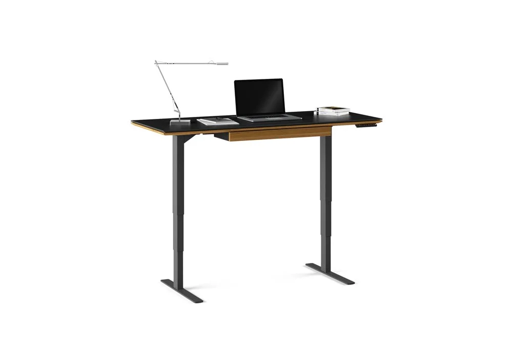 Sequel Lift Desk with black glass top and desk accessories including lamp and keyboard