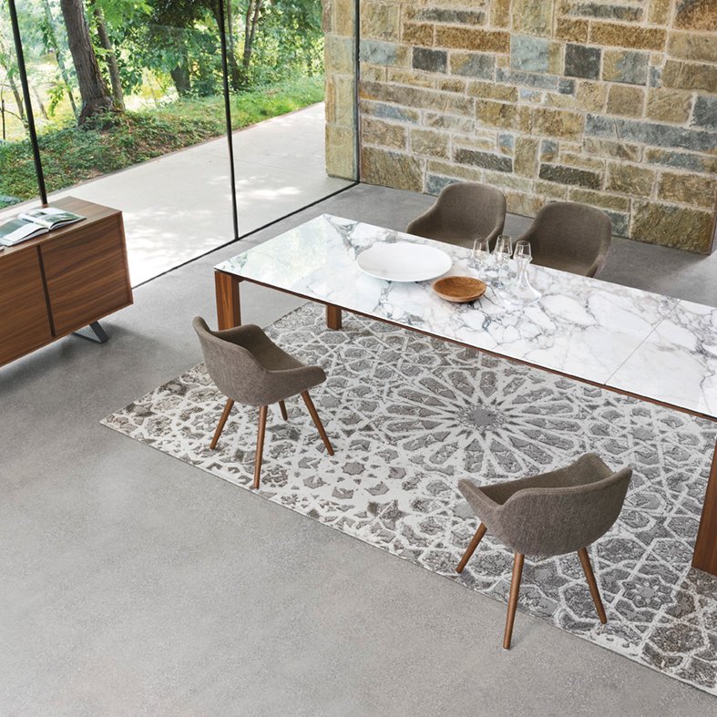 Omnia Table with marble top styled in a contemporary glass-walled dining room