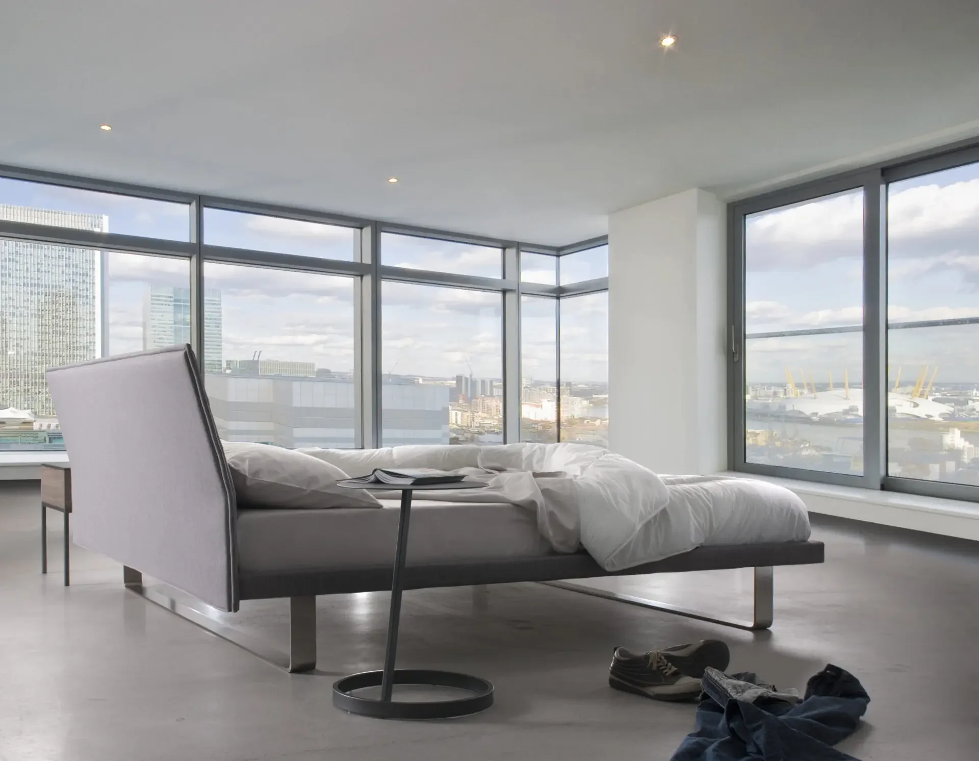 Contemporary high-rise bedroom with Trica Envy Bed facing large windows