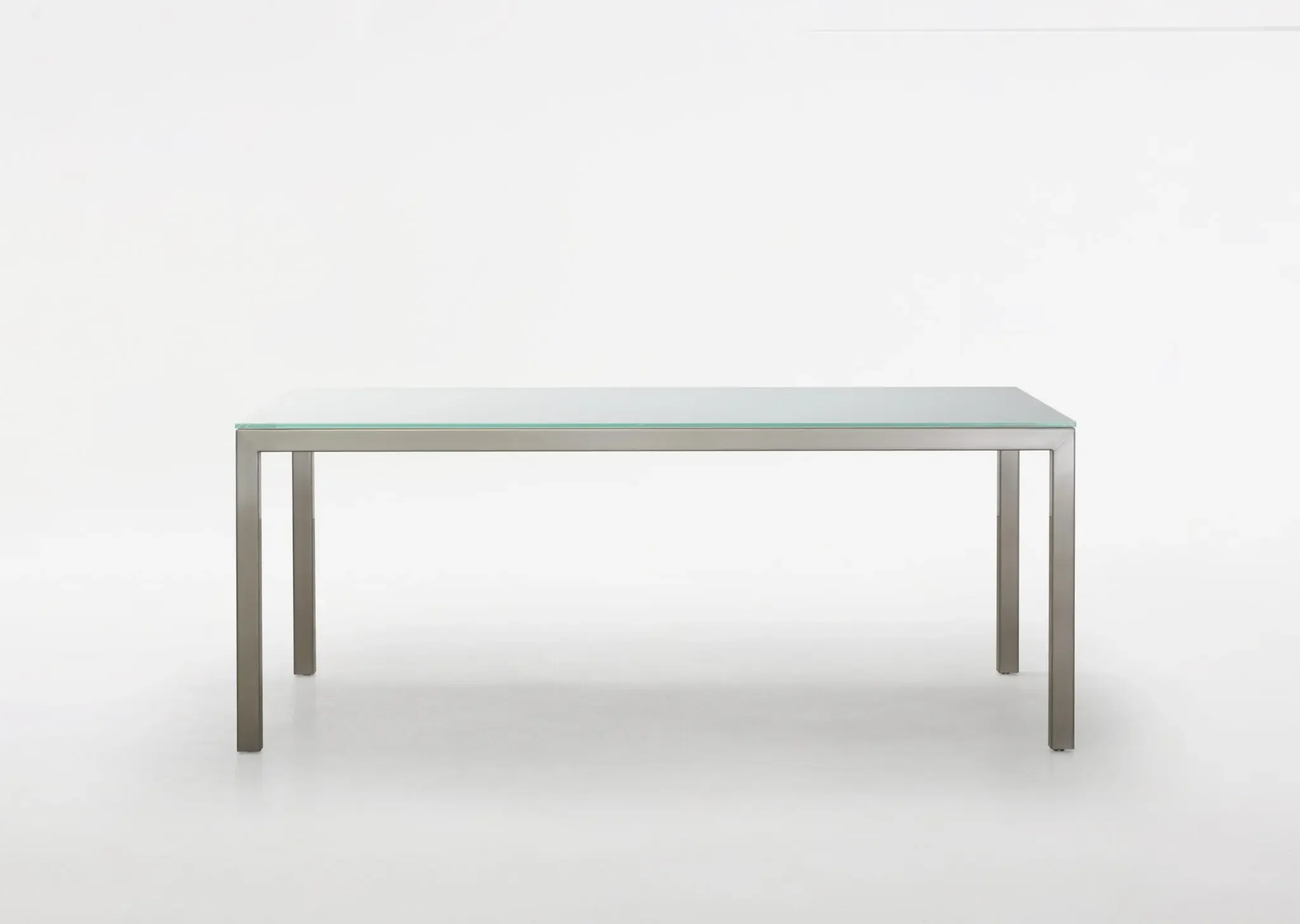 Front view of Trica Cubo Dining Table with glass top and minimalist metal legs