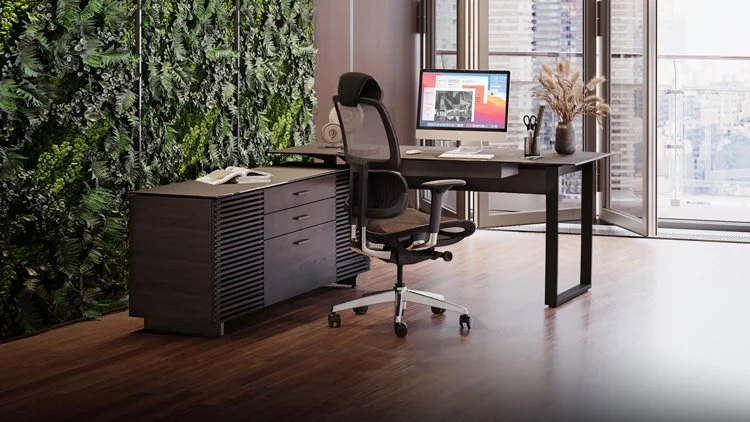 Lifestyle view of Corridor L-Desk in modern office with plant wall, chair, and city view