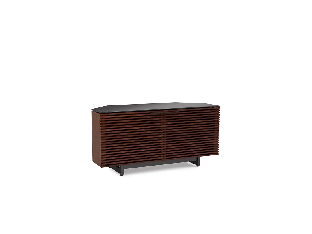 Angled view of the Corridor Corner Media Cabinet in a wood finish with louvered doors