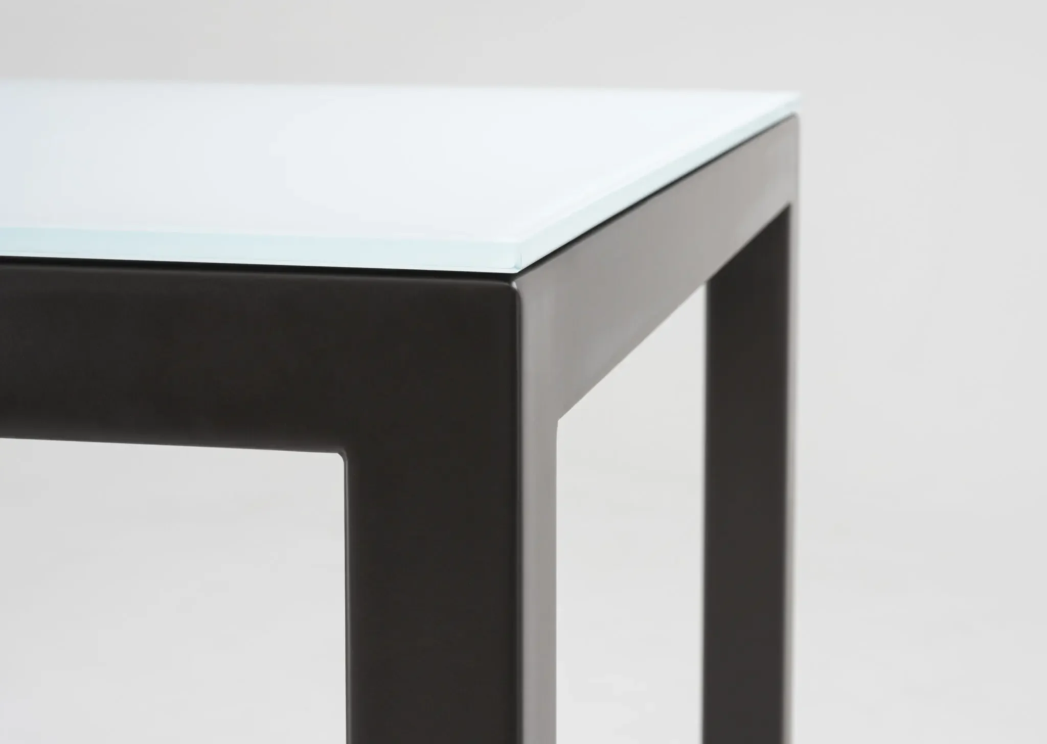 Close-up of glass tabletop and corner detail on Trica Cubo Dining Table