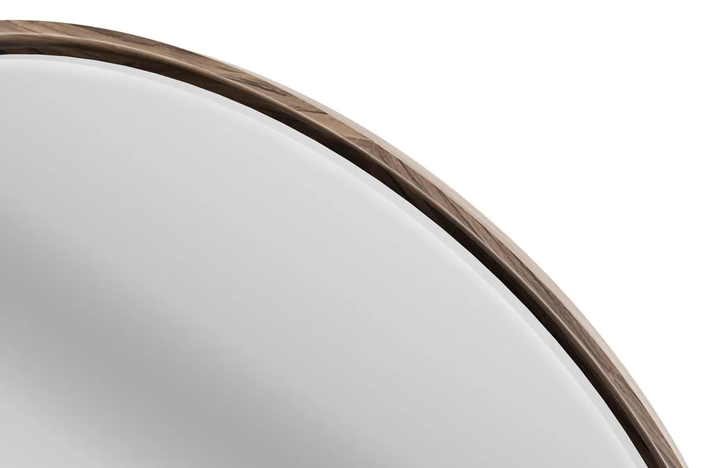 Close-up of LINQ round mirror edge showcasing walnut wood frame and smooth glass finish