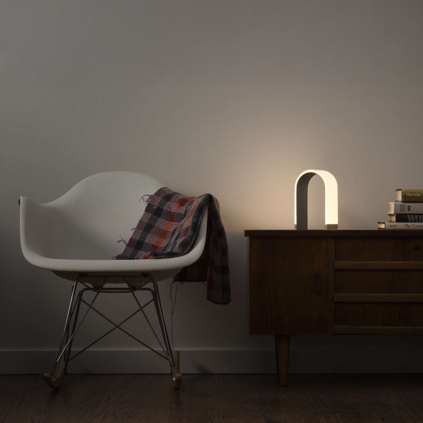 Koncept Mr. N Desk Light illuminating beside a chair in a modern living space